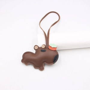 Détail du pendentif Capybara en cuir avec texture litchi et décor d'orange