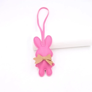 Nahaufnahme vom rosa Leder-Hasenanhänger mit brauner Schleife und feinen Handnähten
