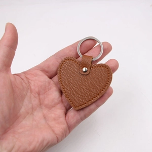Brown heart-shaped leather keychain with palm grain texture and silver metal ring