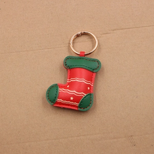 Detail of red and green leather Christmas stocking keychain with metal ring
