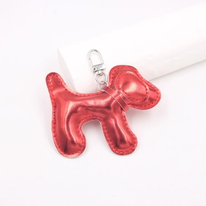 Détail d'un charm chien en cuir PU rouge métallisé avec fermoir mousqueton argenté