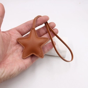 Brown leather star pendant with white stitching and long strap for handbag decoration
