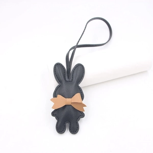 Minimalistischer Kaninchen-Taschenanhänger aus schwarzem Leder mit beiger Schleife