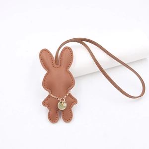Brauner Leder-Kaninchen-Anhänger für Taschen mit goldenem Logo-Tag und Umhängeband