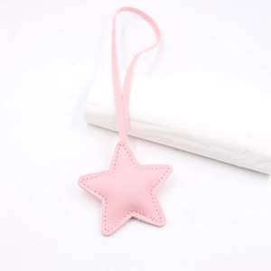 Detail showing pink leather star charm with precise stitching and matching long lanyard