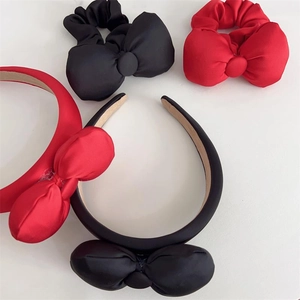 Detailed overhead shot of elegant red and black oversized bow hairbands and scrunchies