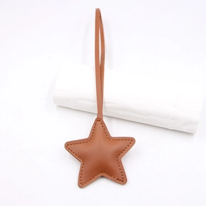 Close-up of brown litchi grain leather star pendant with fine stitching details
