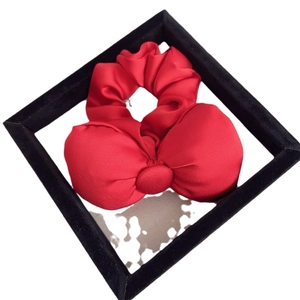 Luxurious red bow hair scrunchie made of shiny silk-like fabric for stylish women's updos
