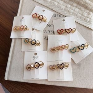 Set of eight heart-shaped enamel hair clips in various colors with gold metal beaded edges