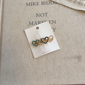 Detail of three-heart metal hair clip with blue enamel on a white display card