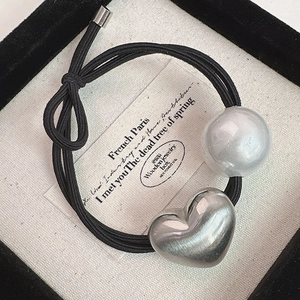 Élastique à cheveux avec cœur et perle au design noir dans un coffret à bijoux