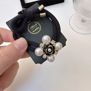Elegant camellia hair tie with pearls and sparkling crystals on handmade card