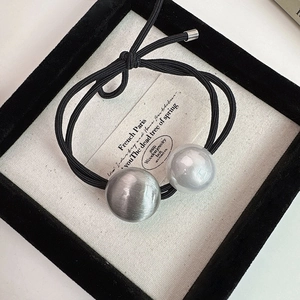 Vue détaillée d'un élastique à cheveux haute élasticité avec perles gris argent et blanc lait