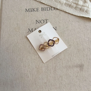 Detail of Korean style gold hair clip with purple enamel on a vintage paper background