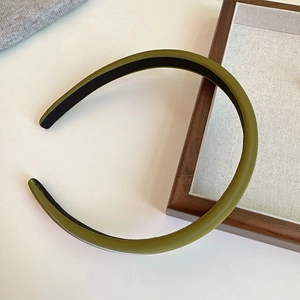 Detail of olive green matte headband with inner non-slip fabric on white desk