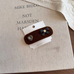 Detail of vintage coffee velvet hair clip with black bow and heart-shaped gemstone