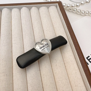 Elegant black leather hair clip with a silver metallic heart and CHALEN logo detail