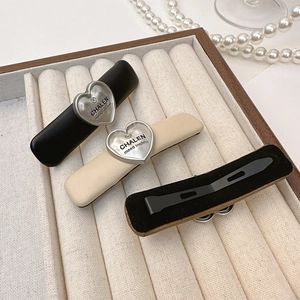 Close-up of heart-shaped metal plates and PU leather clips in a jewelry box