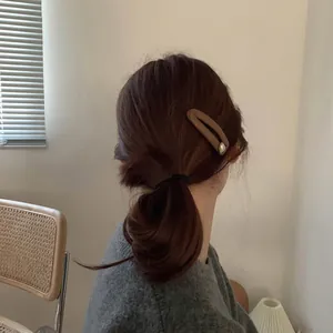 Brown matte French hair clip set with pearl accent and black elastic band on model hair