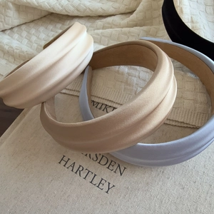 Detailed view of padded satin headbands in beige, khaki, blue, and black colors