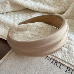 Detail of satin padded headband showing luxury pleated texture and champagne silk finish