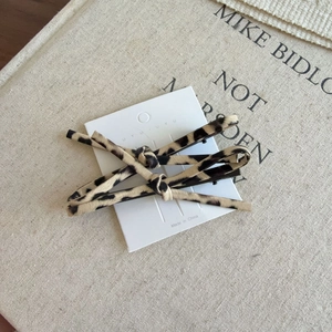 Leopard print hair clip set with two duckbill clips on a beige aesthetic background