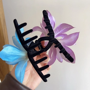 Detail showing high-quality fabric lily flowers on a black flocking shark hair clip