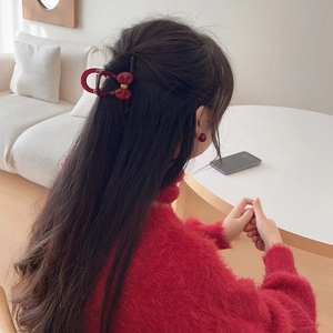 Elegant burgundy bow hair claw clip and matching studs set on a stylish woman