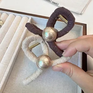 Elegant knit-wrapped hair claw clips in brown and cream with a golden sphere bead