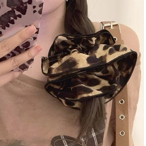 Detail of a large leopard print scrunchie showing the soft velvet fabric texture and pattern