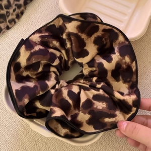 Chic leopard print scrunchie for ponytails with black edge piping and satin texture