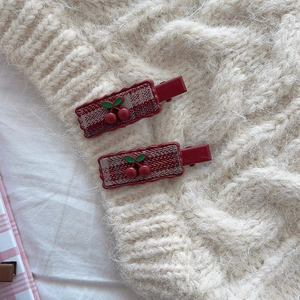 Retro plaid cherry hair clips with red fabric inlay on ivory knit background