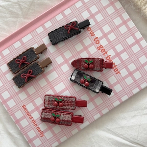 Vintage checkered cherry heart metal hair clips set on a decorative pink notebook