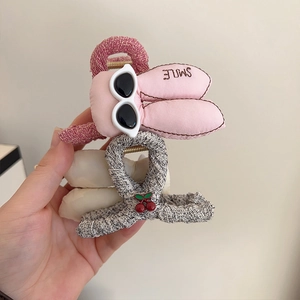 Détail de pince à cheveux oreilles de lapin rose et pince en tweed à cerises