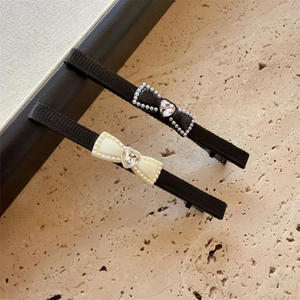 Elegante Haarklammern mit Schleifen, Herzkristallen und Perlen auf Steinoberfläche