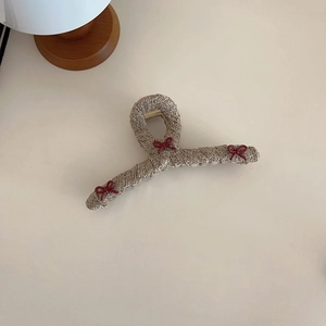 Detail of khaki tweed hair claw clip featuring three elegant deep red bows