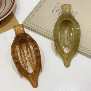 Dettaglio di fermagli per capelli color ambra e oliva in resina sul tavolo