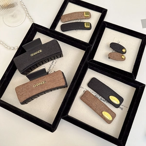 Detail of luxury 6-piece hair claw set with woven texture and gold CHANGE accents