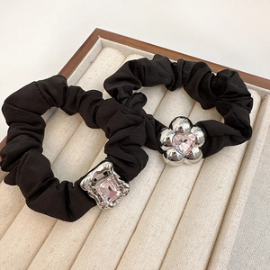 Detail of black hair scrunchies with silver flower and pink crystal stone charms
