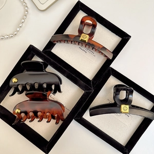 Detail of French vintage hair claws with glossy resin finish and golden smiley face charms