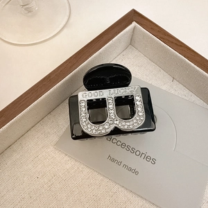 Pince à cheveux élégante en résine noire avec motif double B serti de strass et argent