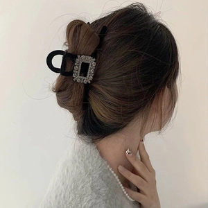 Elegant velvet hair claw clip with rectangular rhinestones shown in a French updo hairstyle