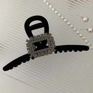 Detail of elegant black velvet hair claw clip with a sparkling rectangular rhinestone buckle
