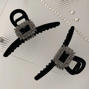 Detail showing two black velvet hair claws with rectangular rhinestone buckles and pearls