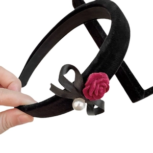 Elegant black velvet headband featuring a vintage red rose bow and faux pearl detail