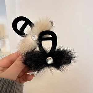 Close-up of elegant faux fur hair claws with velvet texture and square rhinestones