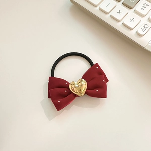 Détail d'un chouchou noeud en velours bordeaux avec breloque coeur doré fait main