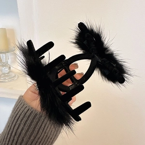 Detail of a large black faux fur shark clip with rhinestones and soft plush texture