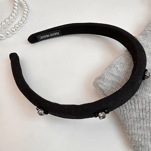 Detail of hand made black knit headband with silver rhinestones and crystal beads