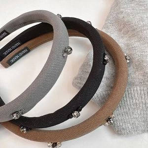 Detailed view of hand-stitched knitted headbands with sparkling crystals and beads